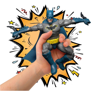 Batman in einer action Pose von einer Menschenhand gehalten